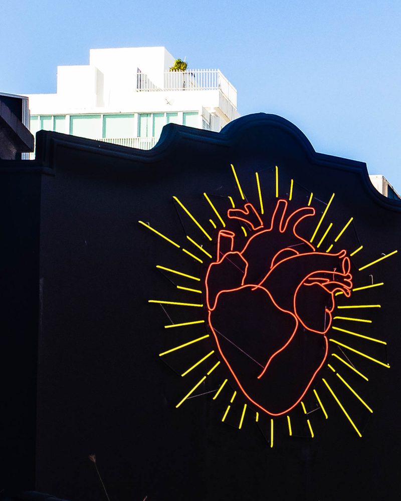 Glowing neon heart sign against a dark background